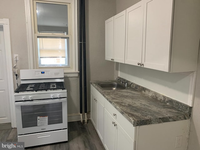 kitchen featuring white cabinets, stainless steel gas range oven, dark hardwood / wood-style flooring, and sink