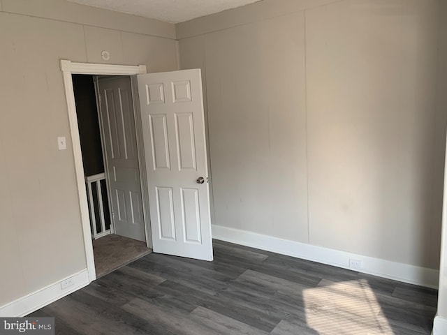 unfurnished room featuring a textured ceiling and dark wood-type flooring