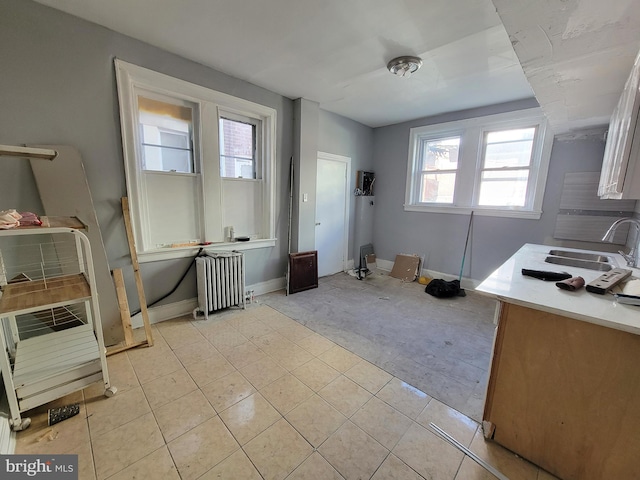 tiled office space featuring radiator and sink