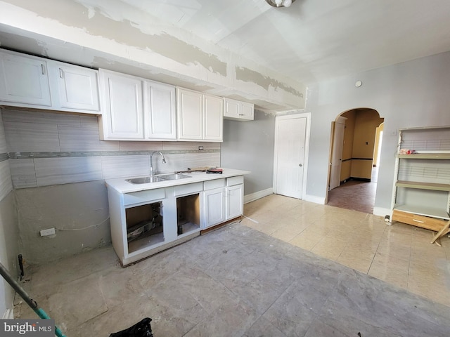 kitchen featuring white cabinets, light tile patterned floors, sink, and tasteful backsplash