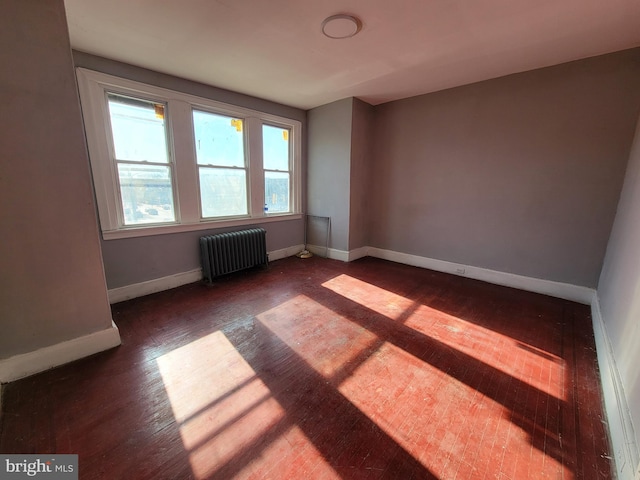 unfurnished room with radiator and dark hardwood / wood-style flooring