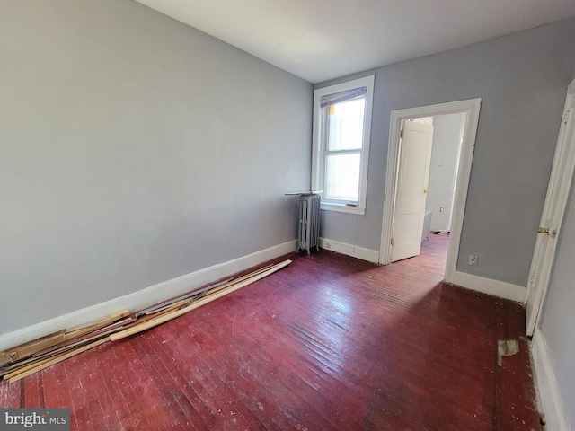 unfurnished room featuring dark wood-type flooring and radiator