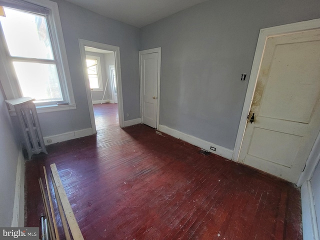 empty room featuring dark hardwood / wood-style floors and radiator