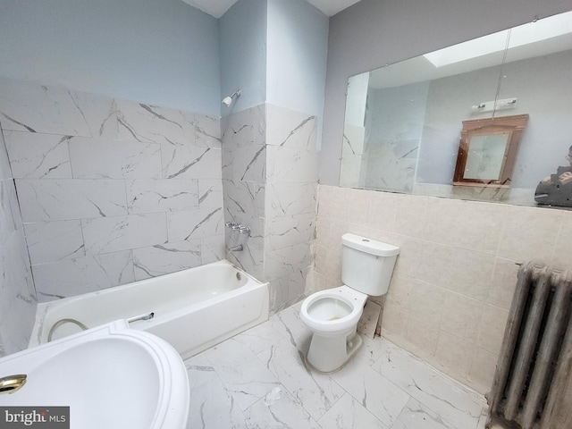 bathroom with shower / tub combination, radiator, a skylight, toilet, and tile walls