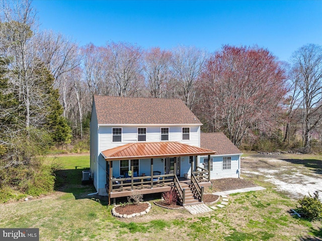 rear view of house featuring a shingled roof, central AC unit, a porch, and a yard