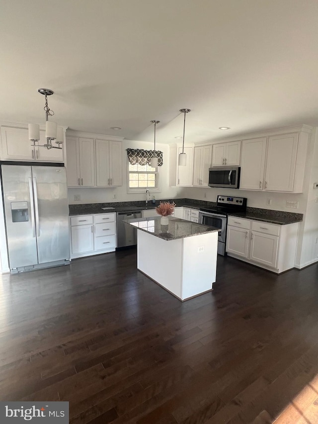 kitchen featuring white cabinetry, a center island, dark hardwood / wood-style flooring, pendant lighting, and stainless steel appliances