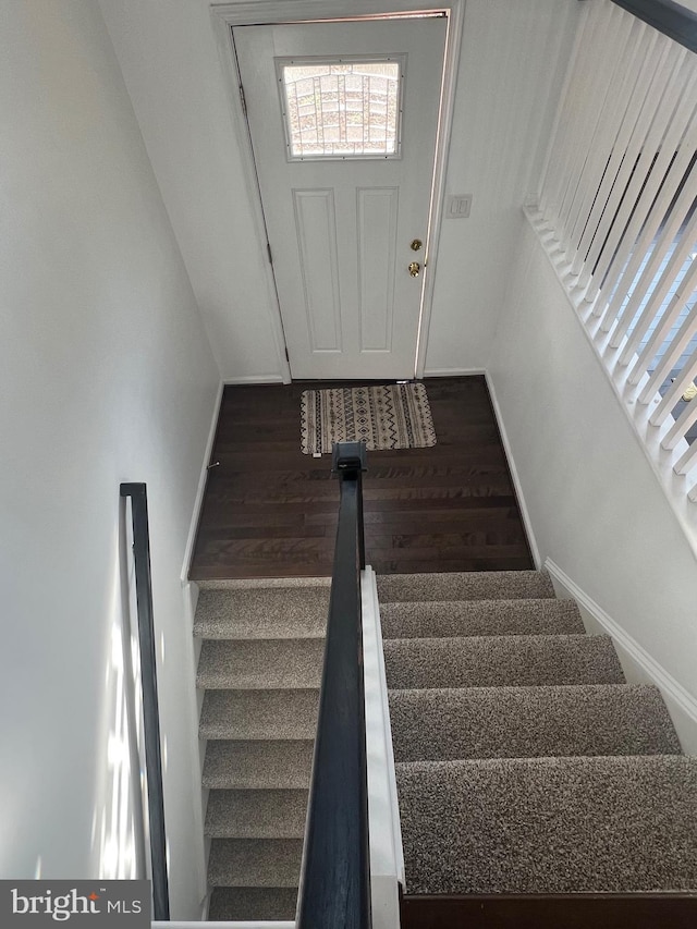 stairs featuring hardwood / wood-style floors