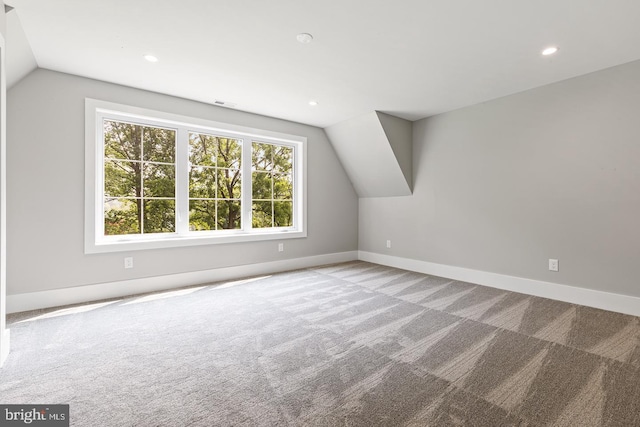 bonus room with light carpet and lofted ceiling