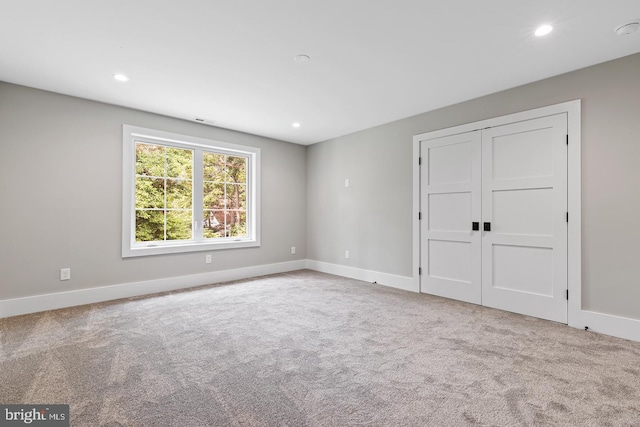 unfurnished bedroom with a closet and light colored carpet