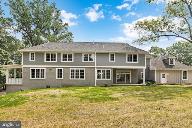 rear view of house featuring a yard