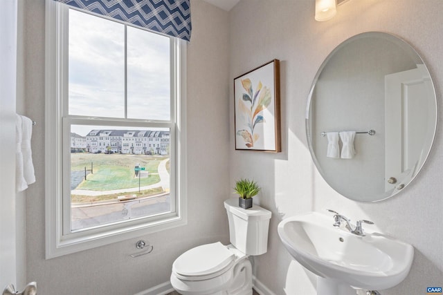 bathroom with sink, a healthy amount of sunlight, and toilet