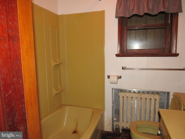 bathroom with radiator heating unit, vanity, and toilet