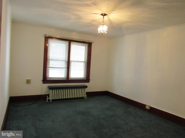 empty room featuring radiator heating unit and dark carpet