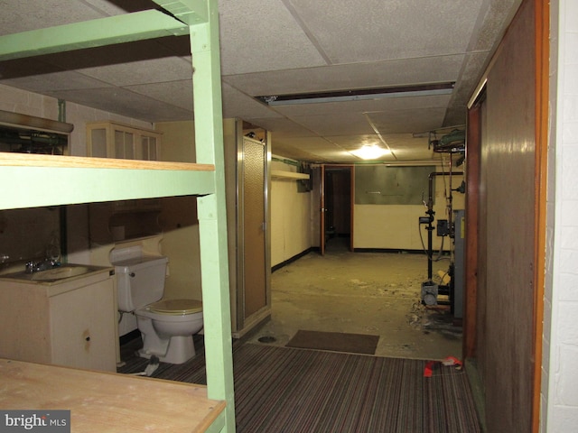 basement with a drop ceiling and sink