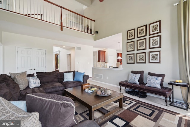 carpeted living room featuring a towering ceiling