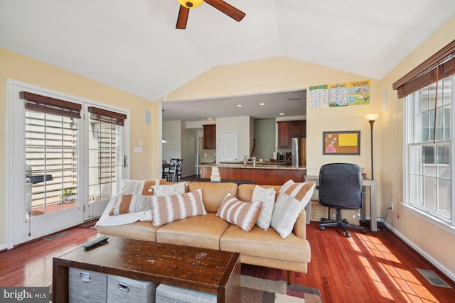 living room with hardwood / wood-style flooring, vaulted ceiling, and ceiling fan