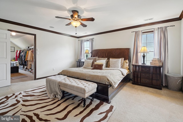 bedroom with crown molding, ceiling fan, a spacious closet, light colored carpet, and a closet