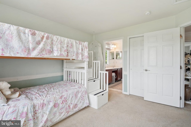 carpeted bedroom with ensuite bath and a closet