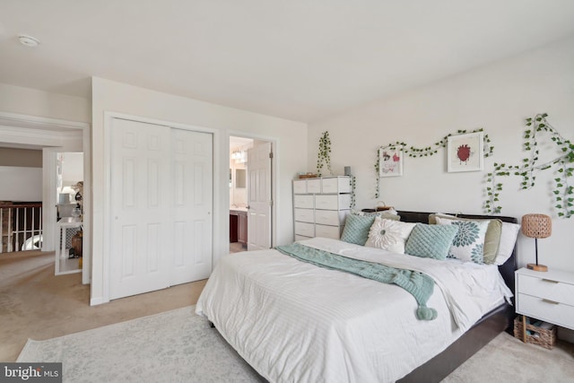 carpeted bedroom featuring ensuite bath and a closet