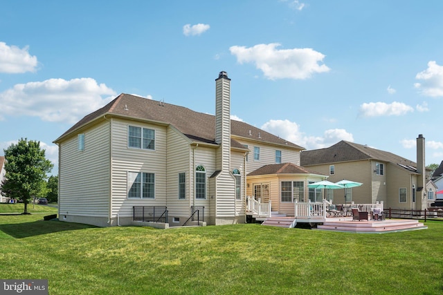 back of property featuring a deck and a yard