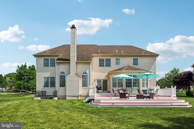 rear view of property with a lawn and a wooden deck