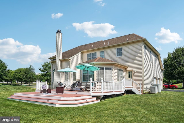 rear view of house featuring cooling unit, a deck, and a yard