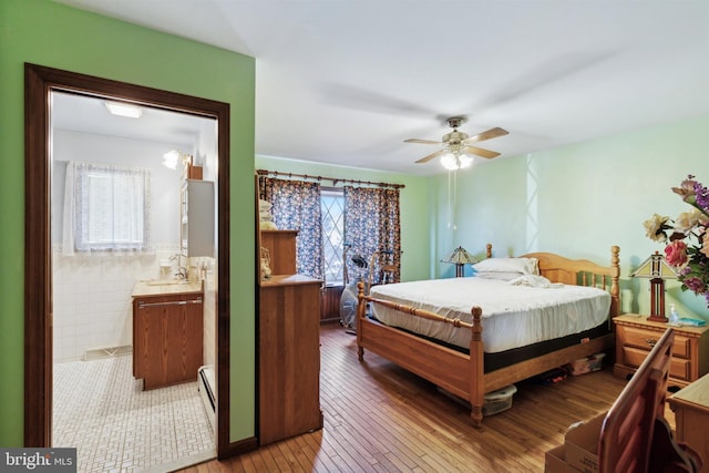 bedroom with hardwood / wood-style flooring, tile walls, multiple windows, and ceiling fan