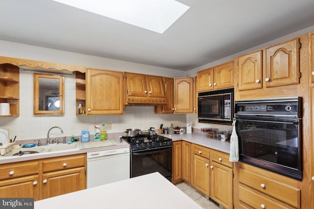 kitchen with backsplash, a skylight, custom range hood, sink, and black appliances