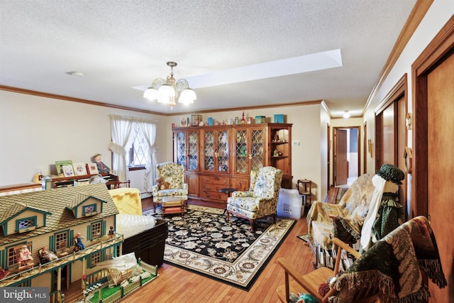 living room with hardwood / wood-style floors, a textured ceiling, an inviting chandelier, and crown molding