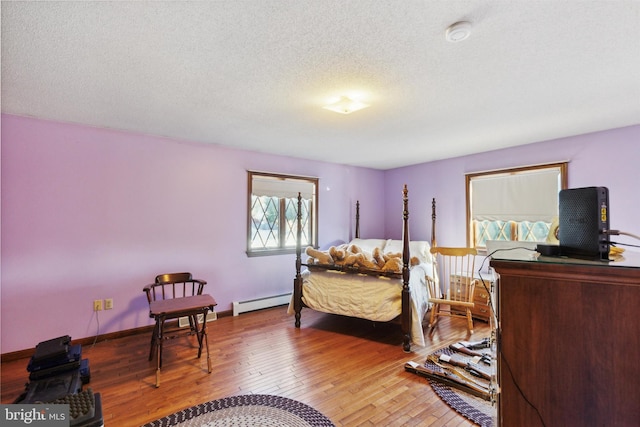 bedroom featuring hardwood / wood-style floors, a textured ceiling, and a baseboard radiator