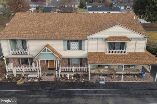 view of front facade with covered porch and a balcony