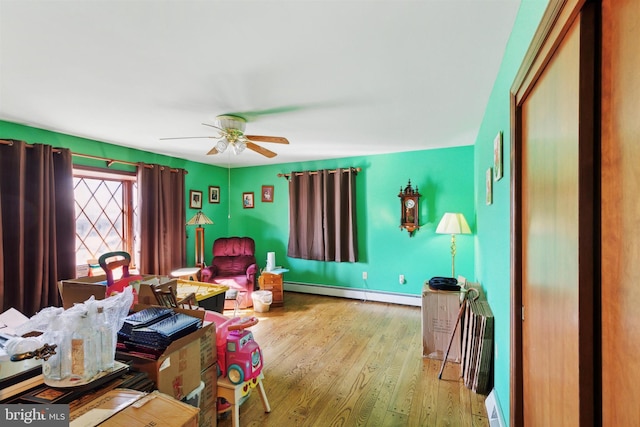 interior space featuring wood-type flooring, a baseboard radiator, and ceiling fan