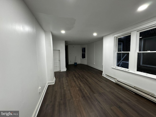 interior space with baseboard heating and dark wood-type flooring