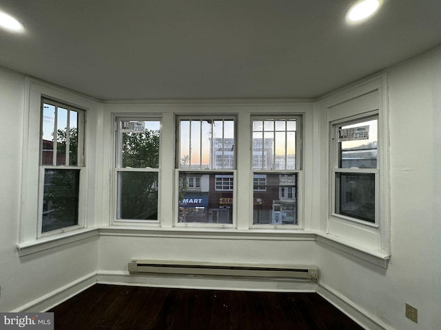 unfurnished sunroom featuring plenty of natural light and a baseboard radiator