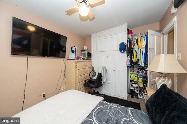 bedroom featuring ceiling fan, dark carpet, and a closet