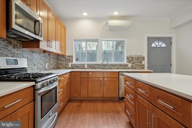 kitchen featuring appliances with stainless steel finishes, light hardwood / wood-style flooring, an AC wall unit, and crown molding