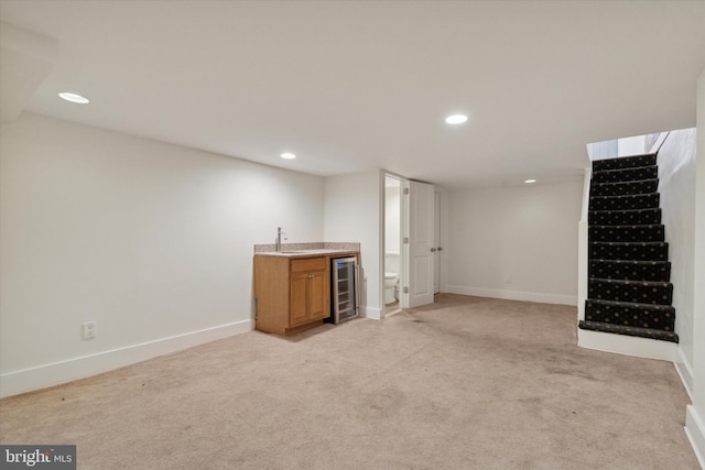 basement featuring indoor wet bar, light colored carpet, and wine cooler