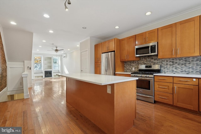 kitchen with a center island, light hardwood / wood-style flooring, ornamental molding, tasteful backsplash, and stainless steel appliances