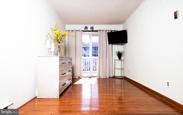 unfurnished bedroom featuring hardwood / wood-style floors and a textured ceiling