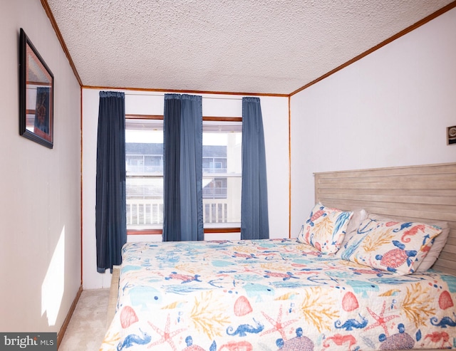 bedroom featuring light colored carpet, ornamental molding, and a textured ceiling