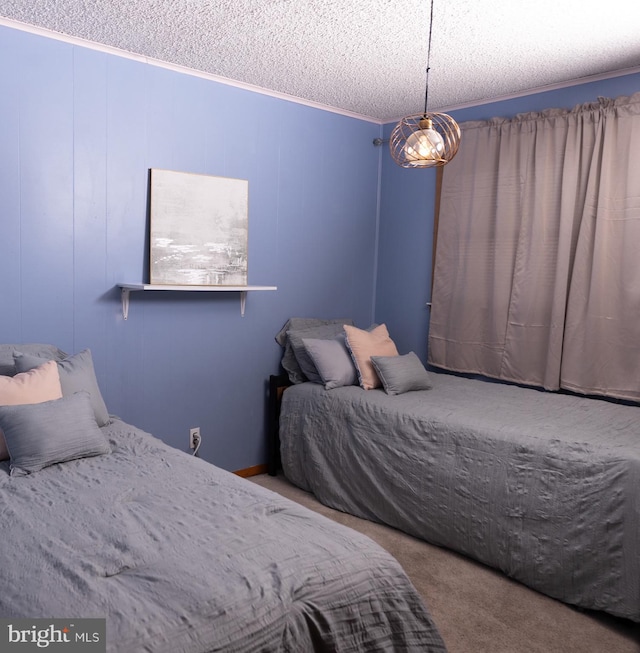 carpeted bedroom with a chandelier, a textured ceiling, and ornamental molding