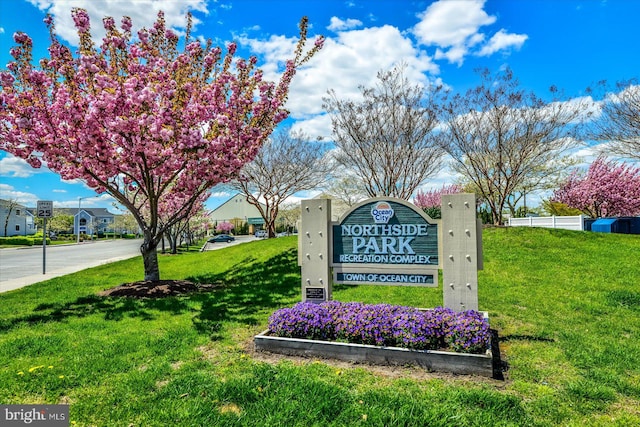 community / neighborhood sign featuring a lawn