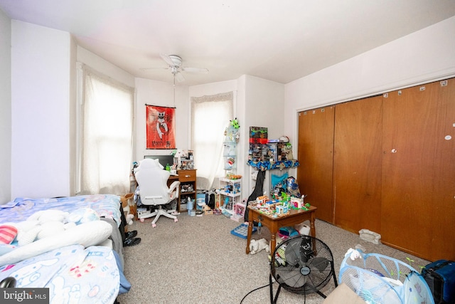 carpeted bedroom featuring ceiling fan, multiple windows, and a closet