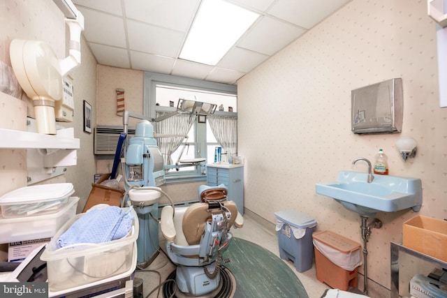 miscellaneous room with a paneled ceiling, sink, and light colored carpet