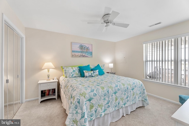 bedroom with ceiling fan, a closet, and light colored carpet