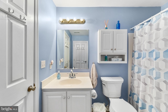 bathroom featuring walk in shower, vanity, and toilet