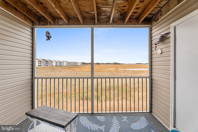 unfurnished sunroom featuring beamed ceiling