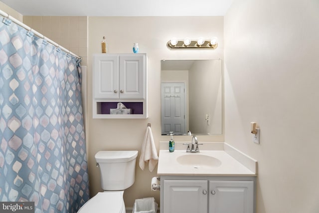 bathroom featuring a shower with shower curtain, vanity, and toilet