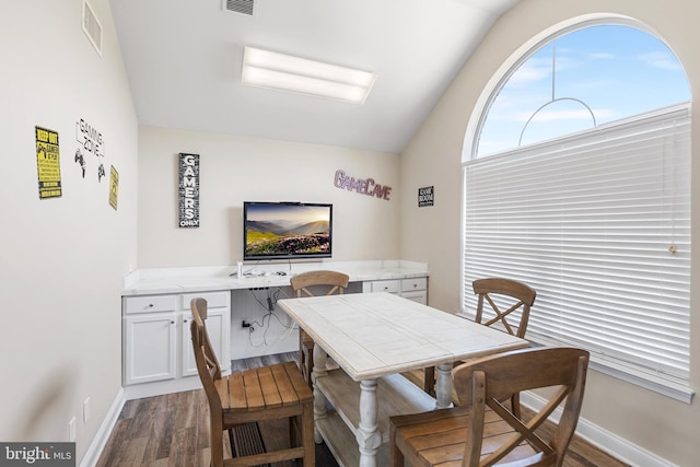 dining area featuring dark wood-type flooring and lofted ceiling