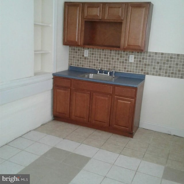 kitchen with backsplash, sink, and light tile patterned floors